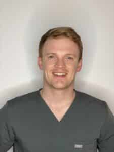 Image of Barney wearing a grey scrub top smiling at the camera.